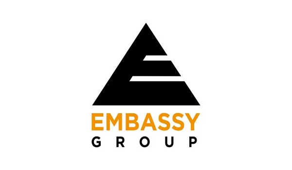 The official corporate branding banner for Embassy Group, featuring the brand logo set against a high-end background of modern architectural designs and luxury residential developments.